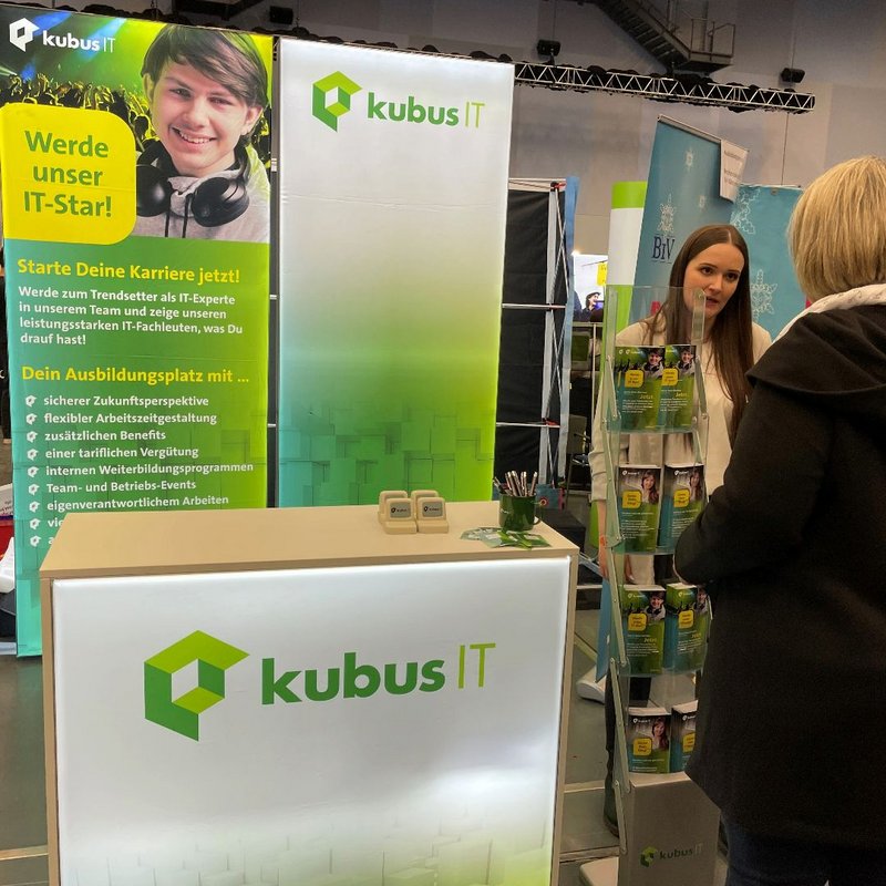 Eine Mitarbeiterin der kubus IT ist am Messestand im Gespräch mit einer Frau Eine Mitarbeiterin der kubus IT ist am Messestand im Gespräch mit einer Frau
